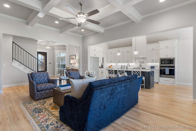 living area with stairway, ceiling fan, coffered ceiling, and light wood-type flooring