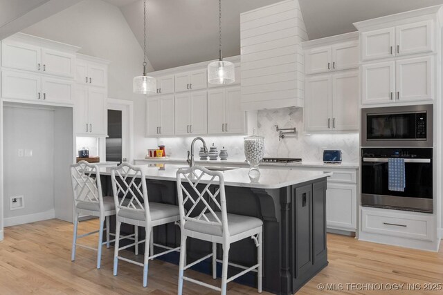 kitchen featuring light countertops, appliances with stainless steel finishes, backsplash, and white cabinetry