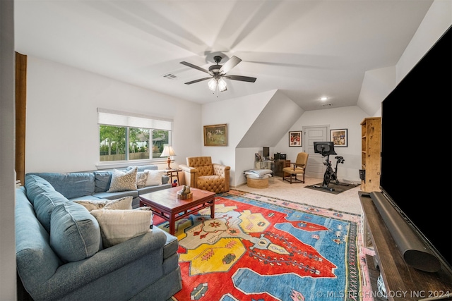 carpeted living room with ceiling fan and vaulted ceiling