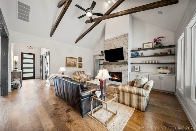 living room with beamed ceiling, hardwood / wood-style flooring, a brick fireplace, high vaulted ceiling, and ceiling fan