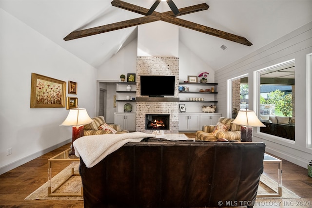 living room featuring a fireplace, brick wall, beamed ceiling, hardwood / wood-style flooring, and built in shelves