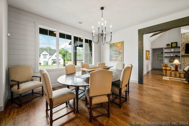 dining area with dark wood-type flooring, built in features, and a chandelier