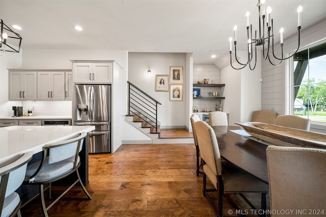 dining room with a notable chandelier, hardwood / wood-style floors, and lofted ceiling