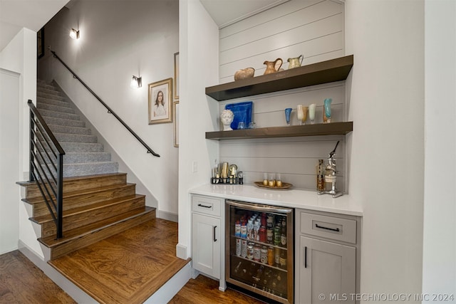 bar featuring wine cooler and dark wood-type flooring