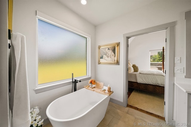 bathroom featuring a bath to relax in and tile floors