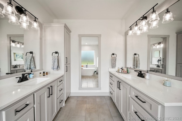 bathroom featuring a washtub, tile flooring, and double vanity