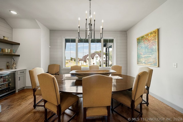 dining room featuring dark hardwood / wood-style floors, beverage cooler, and an inviting chandelier