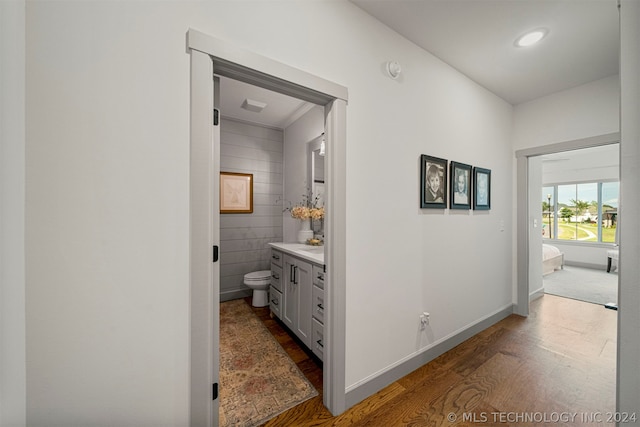 corridor with hardwood / wood-style flooring and tile walls