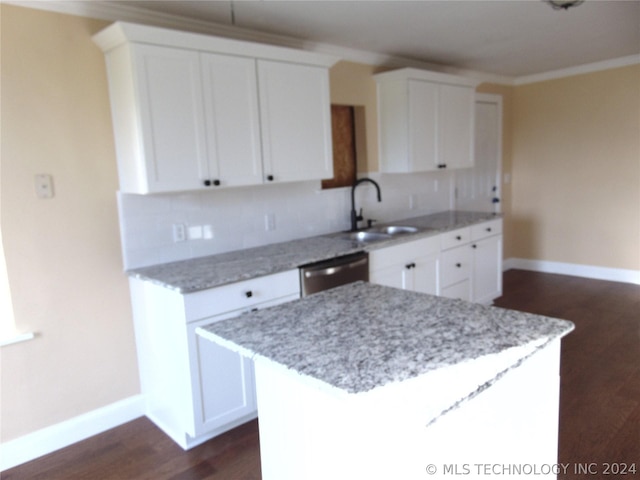 kitchen featuring sink, a kitchen island, stainless steel dishwasher, decorative backsplash, and white cabinets