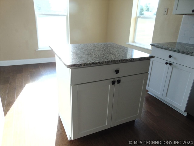 kitchen featuring white cabinetry, a center island, a healthy amount of sunlight, and dark hardwood / wood-style floors