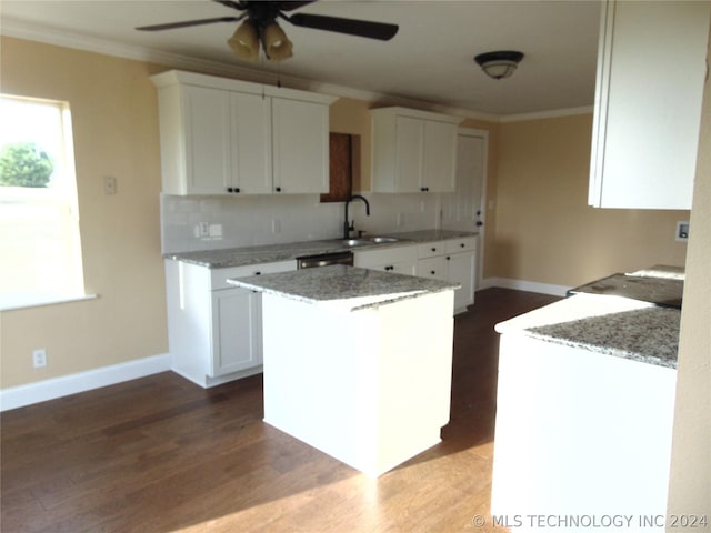 kitchen featuring a center island, backsplash, white cabinets, sink, and hardwood / wood-style flooring