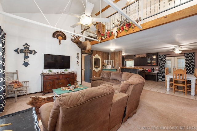 tiled living room with french doors, ceiling fan, and a towering ceiling