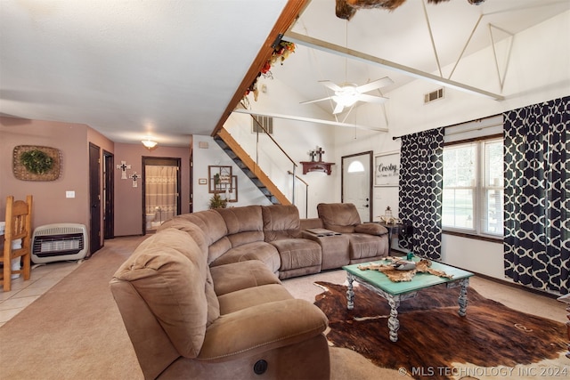 living room featuring a towering ceiling, light carpet, ceiling fan, and heating unit