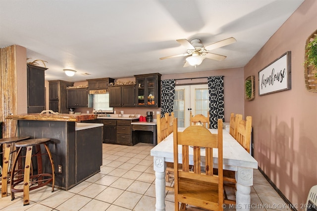 dining space with sink, light tile patterned floors, ceiling fan, and french doors