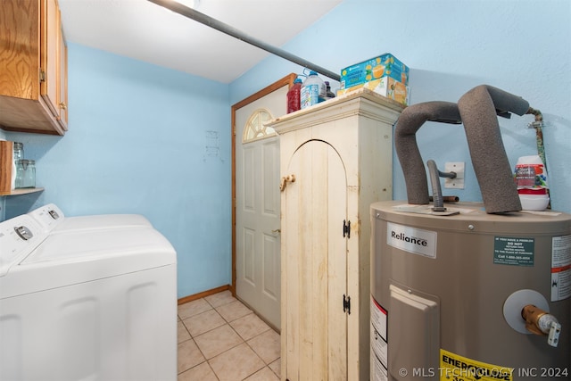 laundry area with washing machine and clothes dryer, light tile patterned flooring, water heater, and cabinets