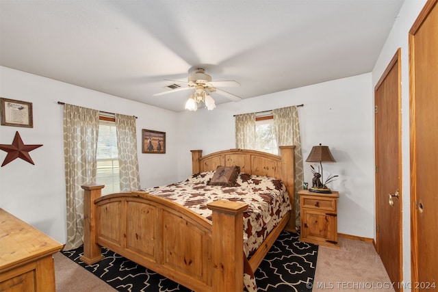 bedroom featuring light colored carpet, ceiling fan, and a closet