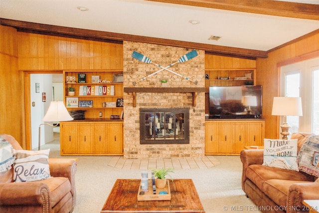 living room with vaulted ceiling with beams, wood walls, built in shelves, carpet floors, and a brick fireplace