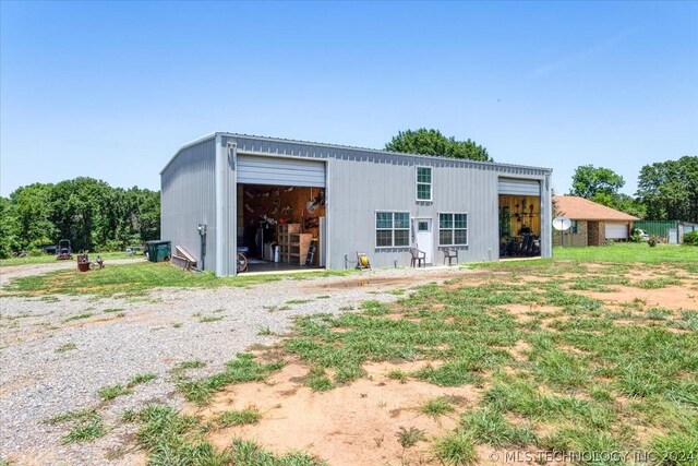 back of property featuring a garage and an outbuilding