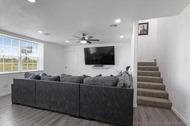 living room with stairs, wood finished floors, visible vents, and baseboards