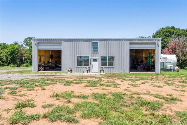 rear view of property featuring board and batten siding, an outbuilding, and a garage