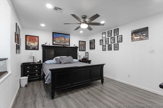 bedroom with recessed lighting, visible vents, baseboards, and wood finished floors