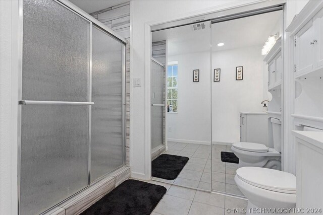 bathroom with visible vents, baseboards, toilet, tile patterned floors, and a shower stall