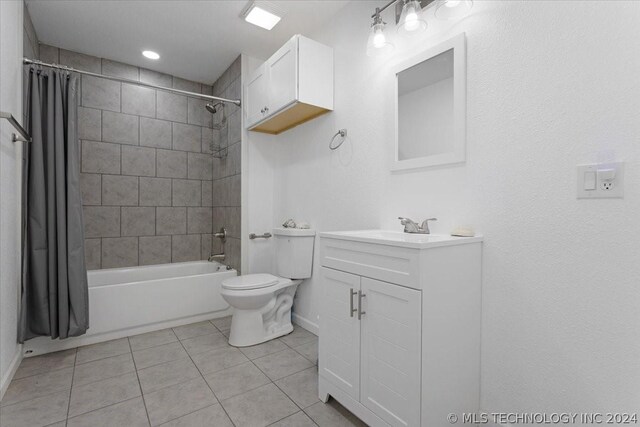 bathroom with baseboards, toilet, shower / tub combo with curtain, tile patterned flooring, and vanity