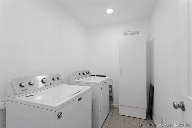 washroom with laundry area, light tile patterned floors, and washing machine and clothes dryer