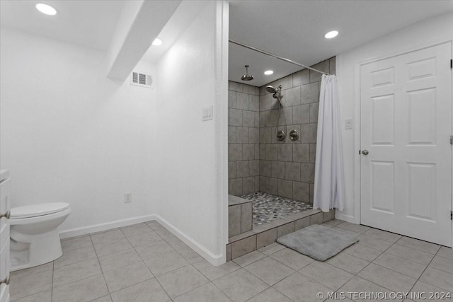 bathroom featuring tile patterned floors, visible vents, baseboards, and a shower stall