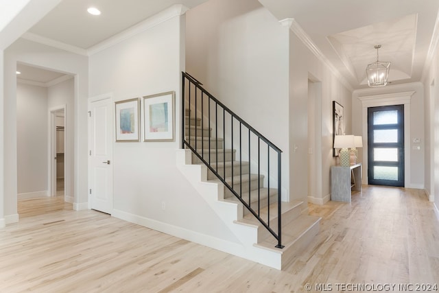 entrance foyer featuring crown molding, a chandelier, and light hardwood / wood-style floors