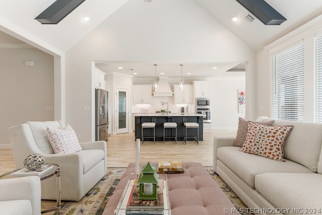 living room featuring high vaulted ceiling and light hardwood / wood-style flooring