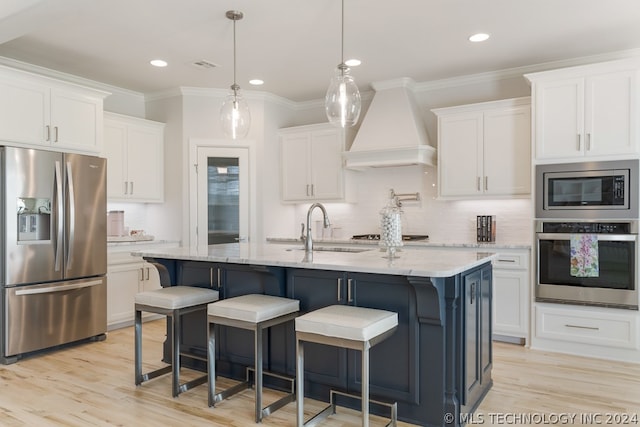 kitchen featuring custom exhaust hood, white cabinetry, sink, appliances with stainless steel finishes, and light hardwood / wood-style floors