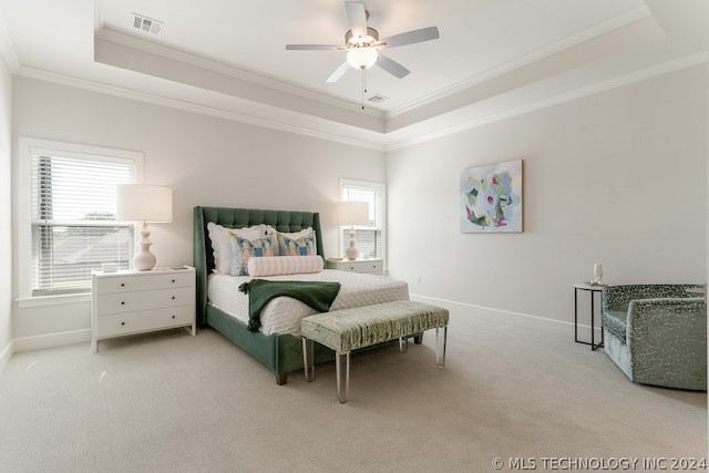 carpeted bedroom featuring a raised ceiling, ceiling fan, and ornamental molding