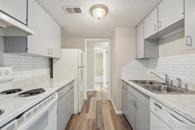 kitchen with white appliances, sink, decorative backsplash, and white cabinets