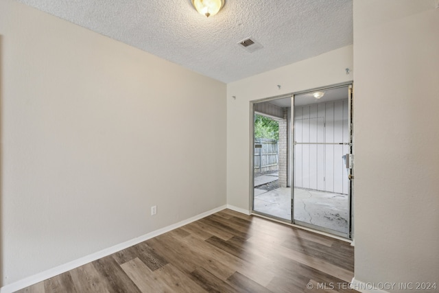 spare room with wood-type flooring and a textured ceiling