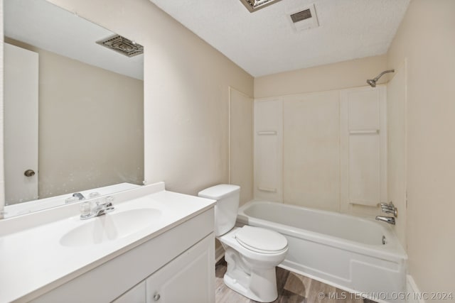 full bathroom with toilet, wood-type flooring, a textured ceiling, vanity, and shower / bath combination