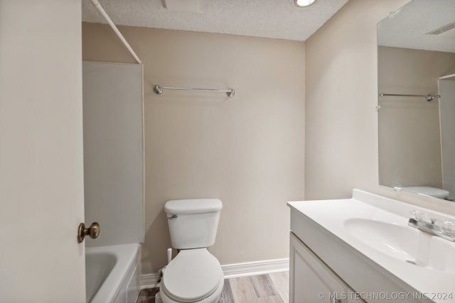 full bathroom featuring toilet, a textured ceiling, shower / bathtub combination, vanity, and hardwood / wood-style floors