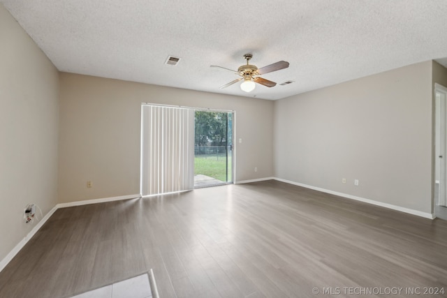 empty room with ceiling fan, hardwood / wood-style floors, and a textured ceiling