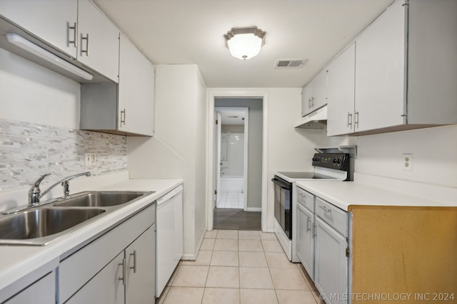 kitchen with light tile patterned floors, sink, electric range oven, white dishwasher, and white cabinets