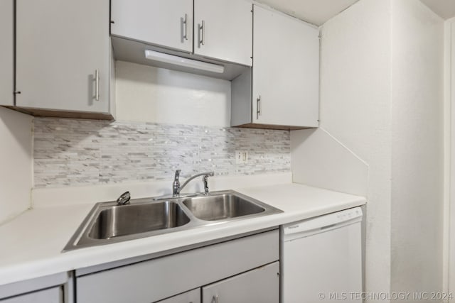 kitchen featuring white cabinets, dishwasher, sink, and backsplash