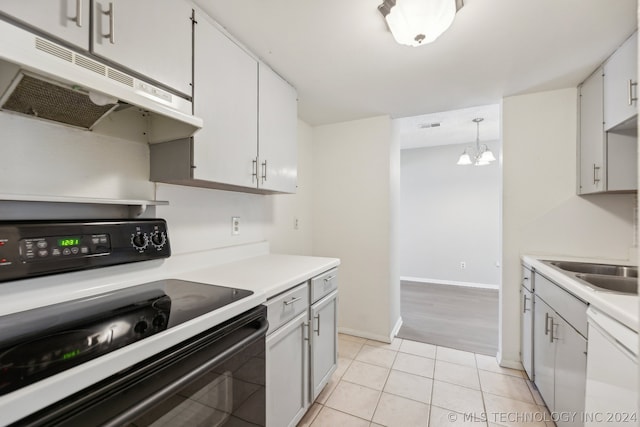 kitchen with light tile patterned flooring, white cabinetry, black electric range, hanging light fixtures, and white dishwasher