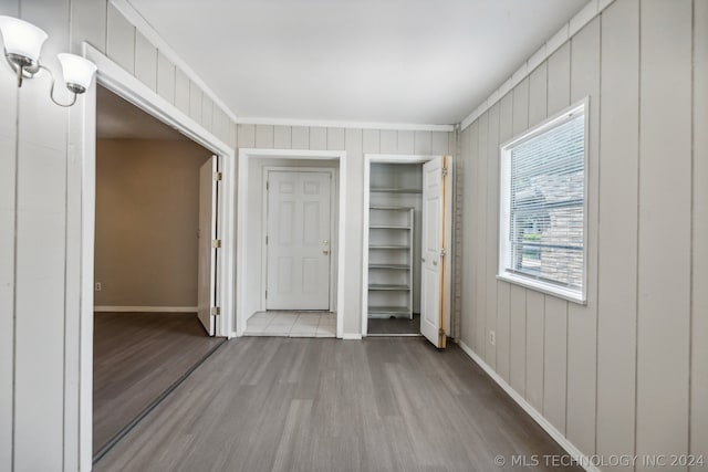 unfurnished bedroom featuring wood-type flooring and ornamental molding