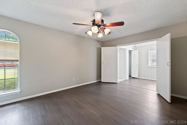 empty room featuring ceiling fan, dark hardwood / wood-style flooring, and a textured ceiling