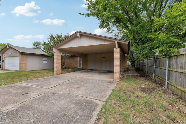 view of front of home featuring a garage, a carport, an outbuilding, and a front yard