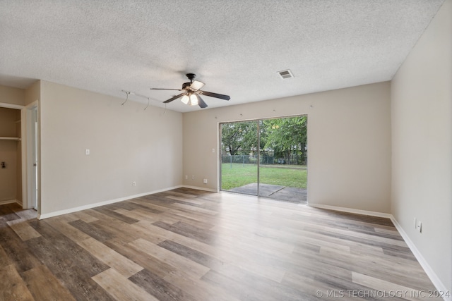 empty room with ceiling fan, a textured ceiling, and light wood-type flooring