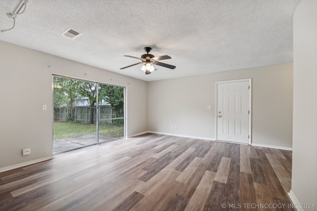 empty room featuring hardwood / wood-style flooring, ceiling fan, and a textured ceiling