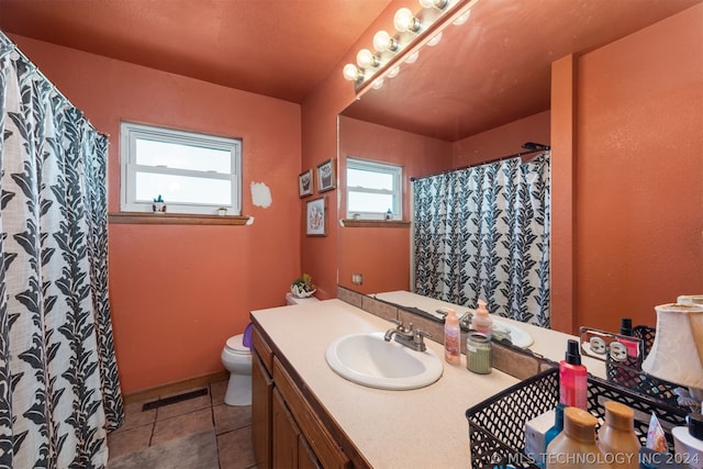 bathroom featuring tile patterned flooring, vanity, and toilet