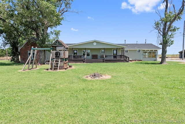 back of property featuring a playground, covered porch, and a lawn