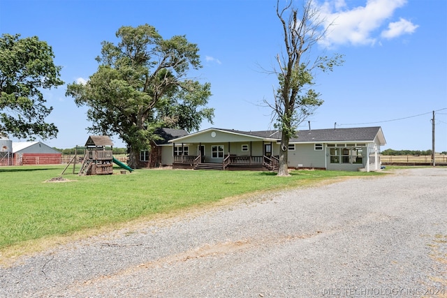 view of front of home featuring a front yard, a playground, and covered porch