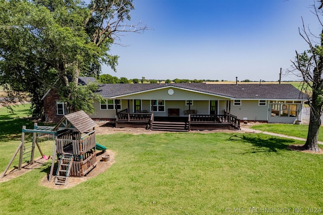 back of property with a playground and a lawn